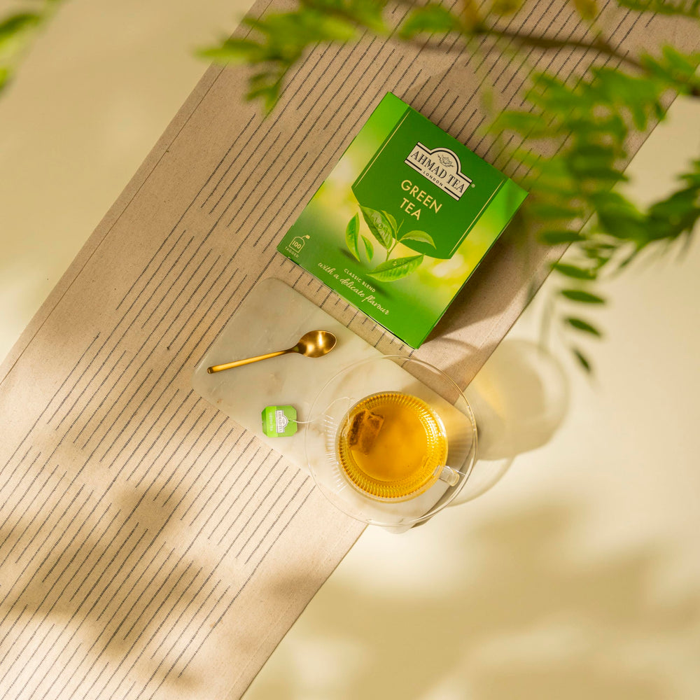 Ahmad Tea caja junto a una mano para comparar tamaño y mostrar cantidad práctica