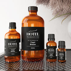 Air-Scent Capri Brezza oil in a glass bottle beside a diffuser setup.