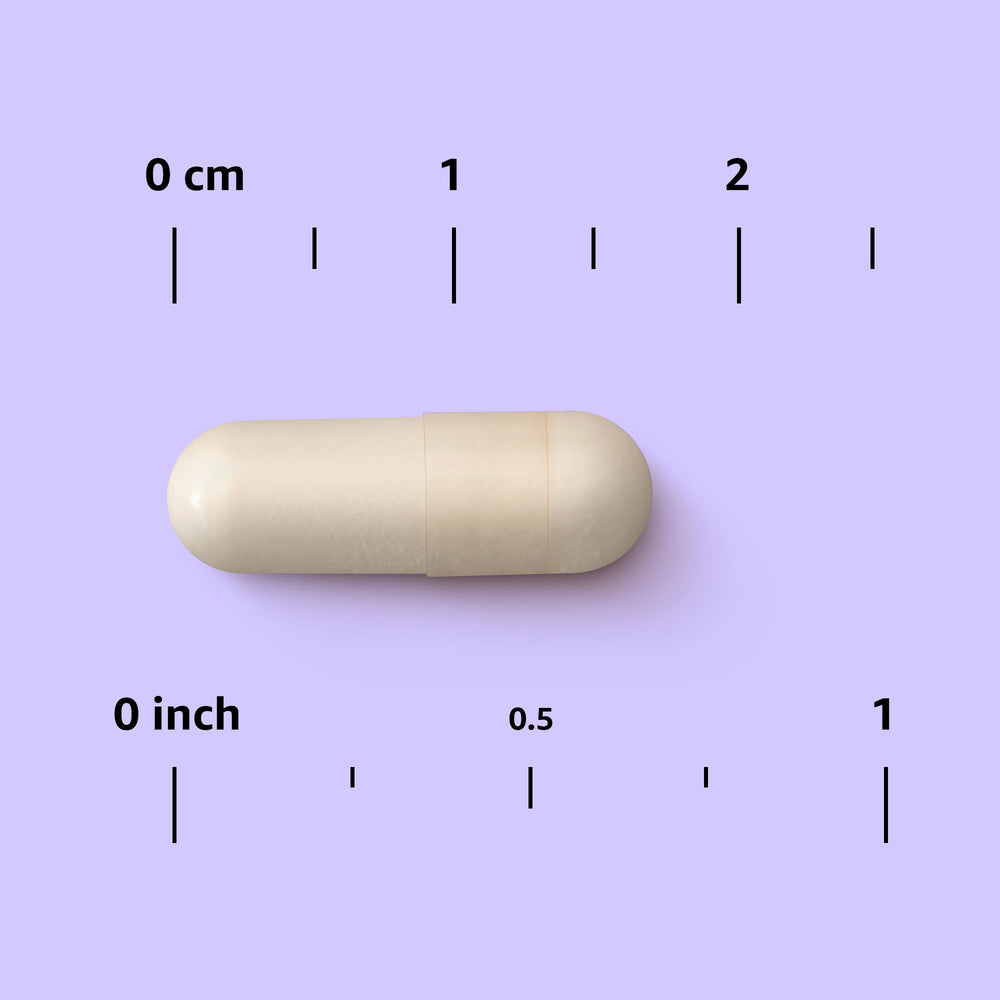 Mano sosteniendo una cápsula Amazon Elements Hierro 18 mg para comparar escala y facilitar dosis