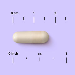 Mano sosteniendo una cápsula Amazon Elements Hierro 18 mg para comparar escala y facilitar dosis