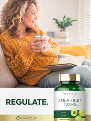 Carlyle frasco junto a fruto amla para mostrar origen natural