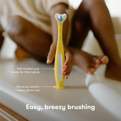 Frida Toothhugger niño cepillándose con supervisión demostrando aprendizaje y hábito saludable