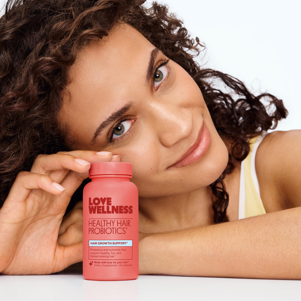 Love Wellness persona tomando una cápsula apoya la rutina cotidiana