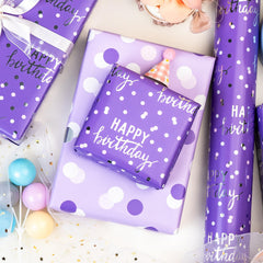 MAYPLUSS papel desplegado mostrando patrón de 'Happy Birthday' y topos, ideal para envolver