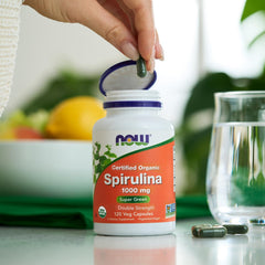 NOW Foods spirulina sobre hojas ilustrando origen vegetal y naturalidad