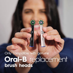 Oral-B Pro 100 junto a un vaso para comparar tamaño y ergonomía