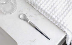Comparación de tamaño del Tongue Sweeper junto a un cepillo dental para referencia