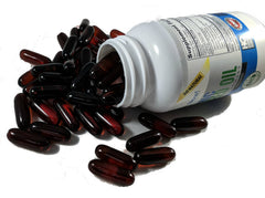 Vitalité Now! cápsula junto a una regla para comparar tamaño y cantidad