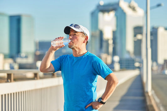Hombre en entorno urbano hidratándose durante su rutina diaria, representando vitaminas y minerales en la vida urbana mexicana