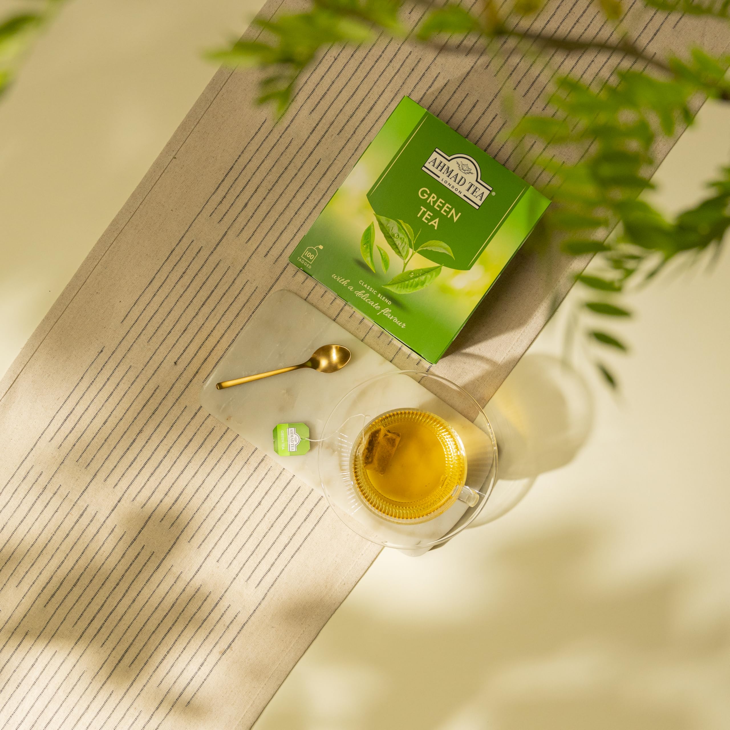 Ahmad Tea caja junto a una mano para comparar tamaño y mostrar cantidad práctica