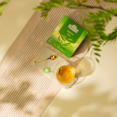 Ahmad Tea caja junto a una mano para comparar tamaño y mostrar cantidad práctica