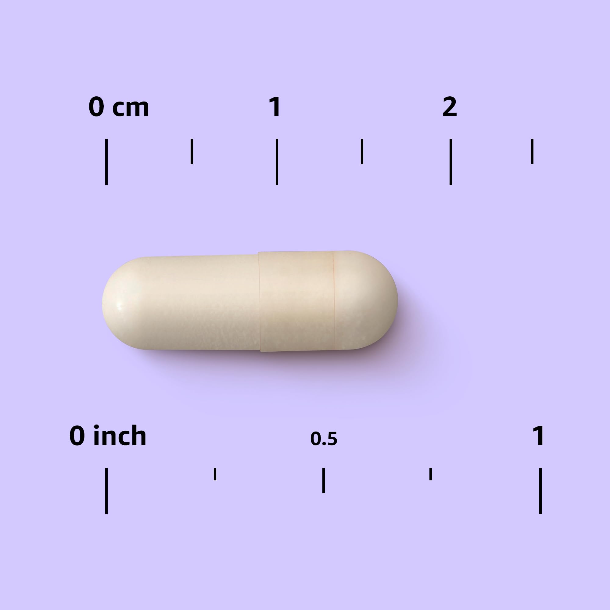 Mano sosteniendo una cápsula Amazon Elements Hierro 18 mg para comparar escala y facilitar dosis