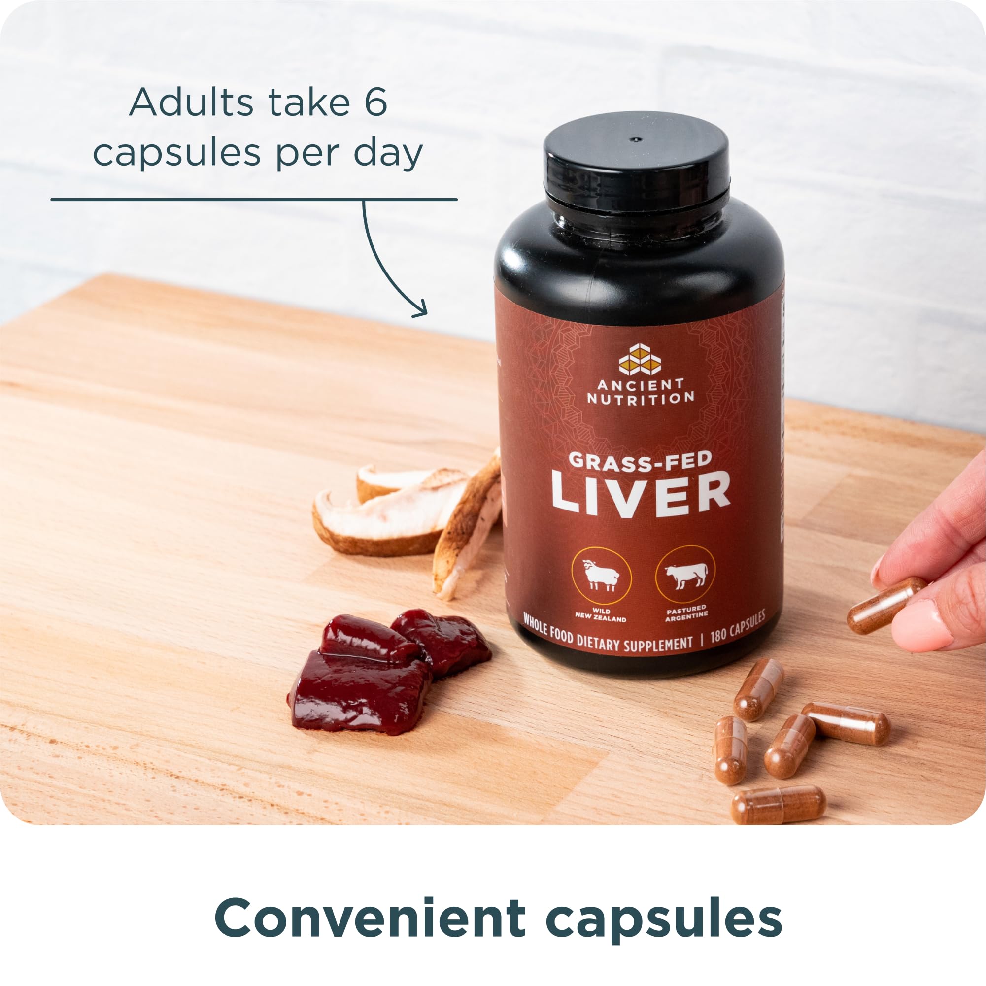 Ancient Nutrition cápsulas en mano para comparar tamaño y dosificación