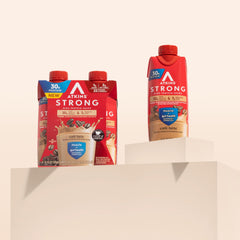 Atkins en mesa de desayuno con frutas, aporta proteína y comodidad