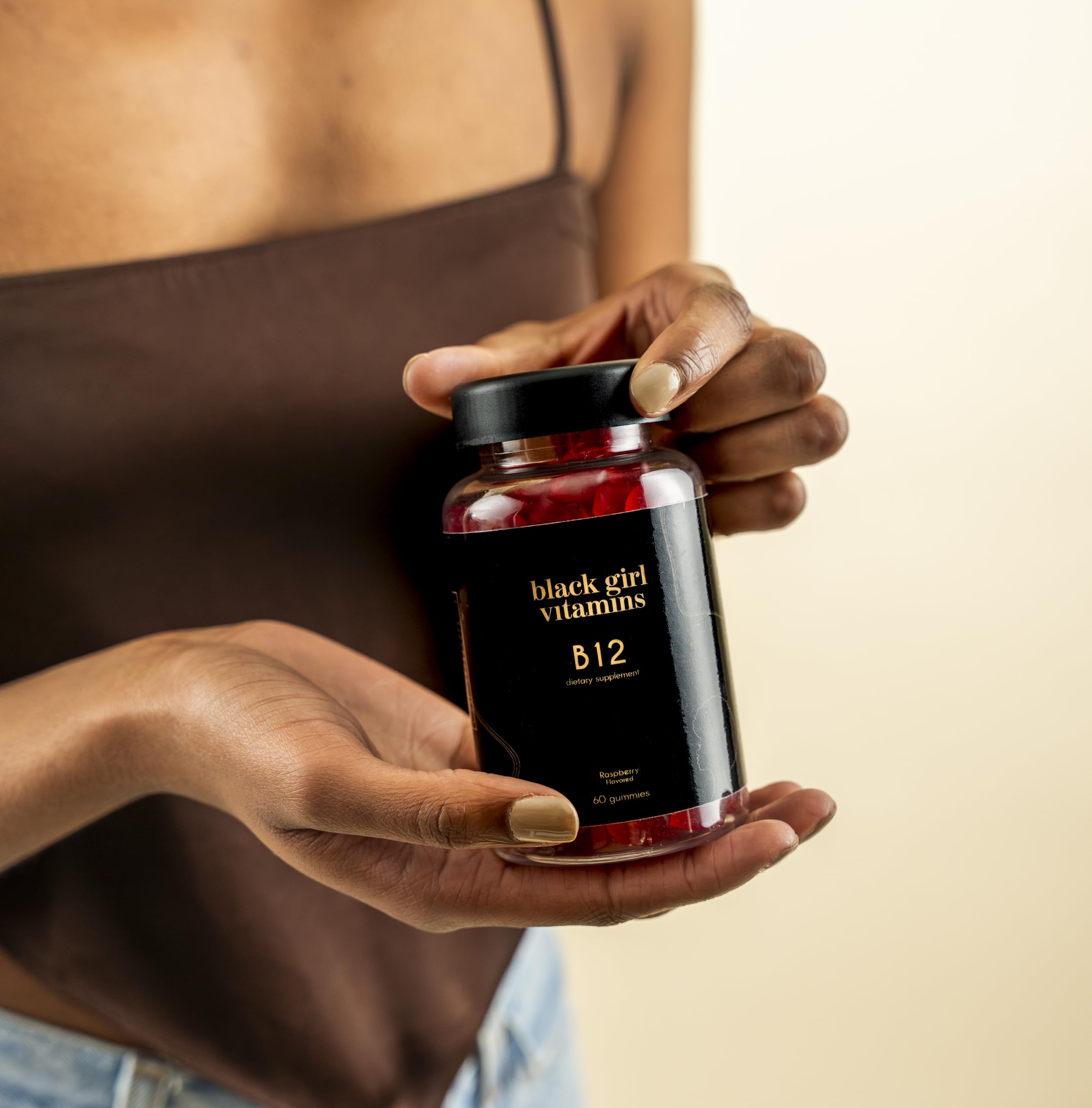 Black Girl Vitamins gomita junto a moneda para escala y conveniencia diaria