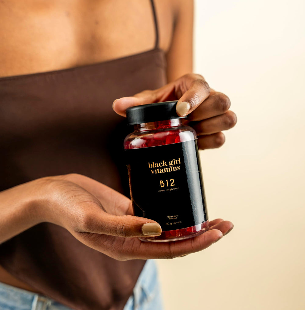 Black Girl Vitamins gomita junto a moneda para escala y conveniencia diaria