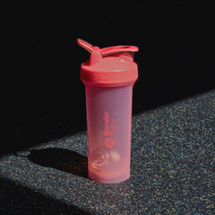BlenderBottle junto a una taza para comparar tamaño y compatibilidad con portavasos