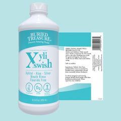 Buried Treasure Xyli Swish botella abierta junto a hojas de menta real refrescante