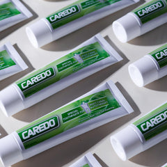 CAREDO tubo en un lavabo moderno, sugiere uso diario y cuidado gingival