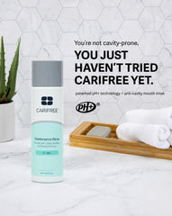 Persona usando CariFree enjuague para refrescar aliento y limpiar