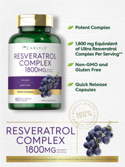 Frasco de Carlyle Resveratrol Complex junto a vaso de agua en mesa de desayuno saludable