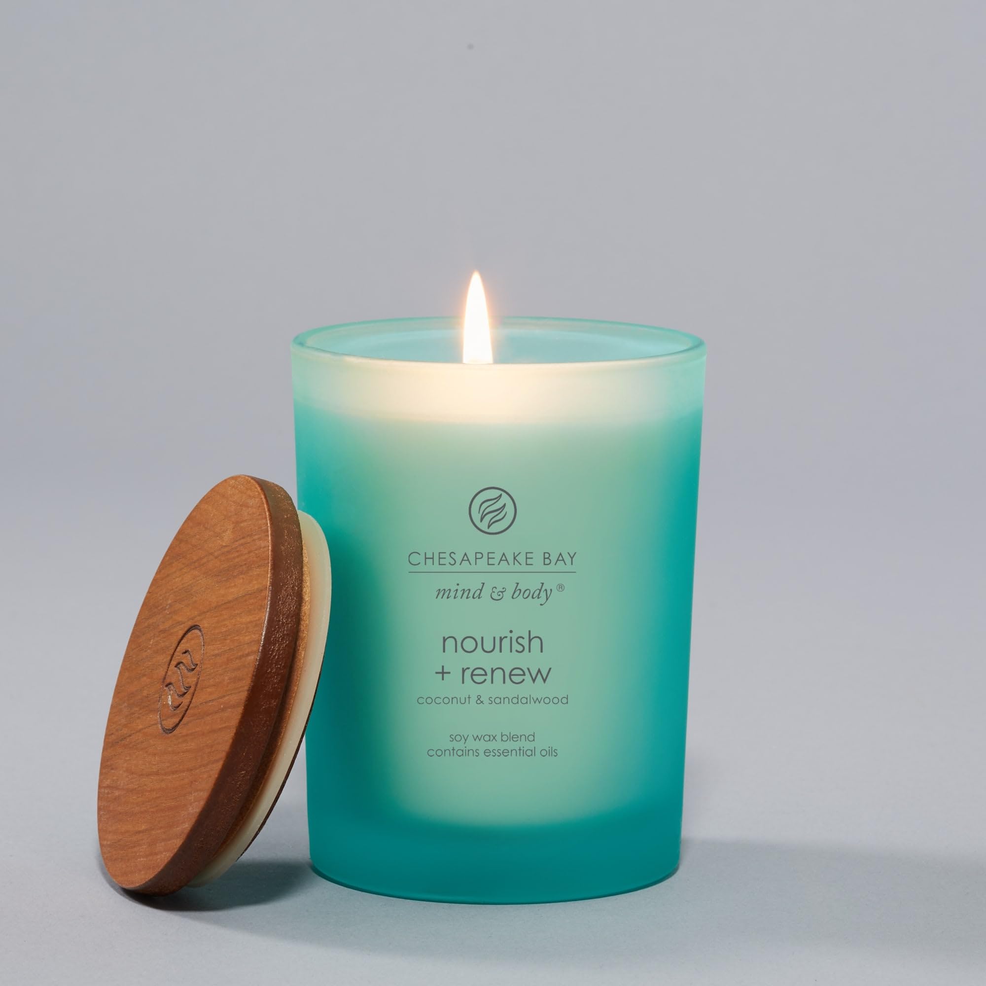 Chesapeake Bay Candle tapa con veta de madera colocada sobre el tarro, conserva aroma y decora