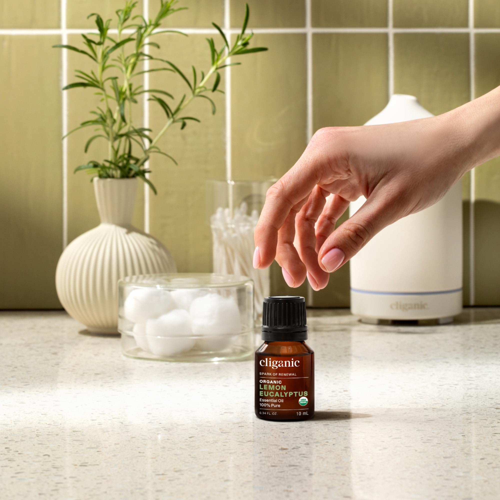 Cliganic frasco 10 ml junto a mano para referencia de tamaño