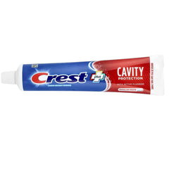 Crest tubo abierto con pasta sobre cepillo demostrando la dosis recomendada