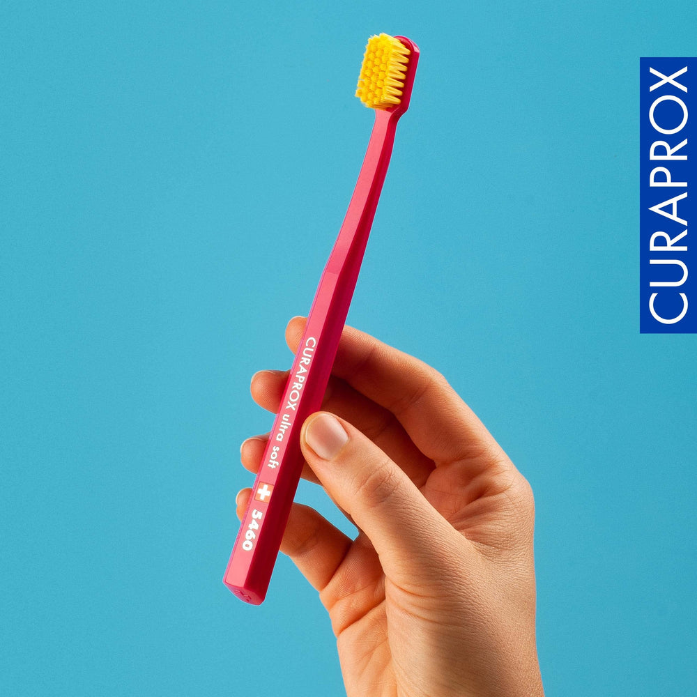 Cepillo Curaprox CS 5460 en mano durante el cepillado, mejor control y técnica correcta