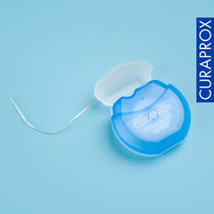 Mano usando Curaprox DF 820 limpiando entre dientes con comodidad