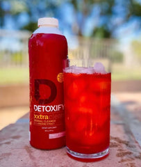 Detoxify producto en ambiente lifestyle con vaso y agua para uso responsable