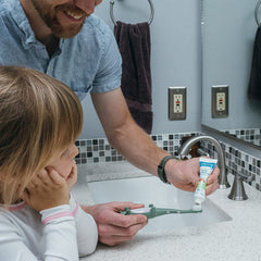 Dr. Brown's familia cepillando a bebé en baño mostrando beneficio rutina diaria agradable