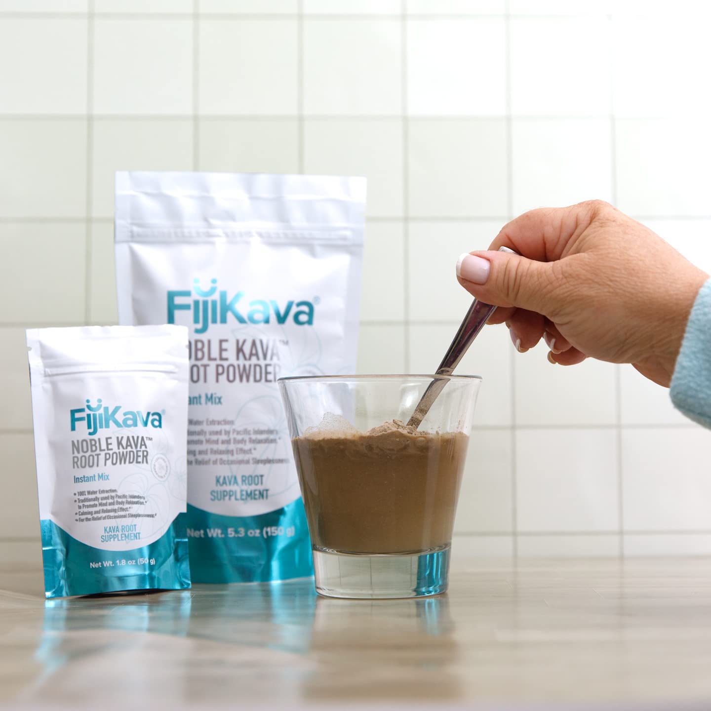 Comparación de tamaño del envase FijiKava 150 g junto a una mano para escala clara