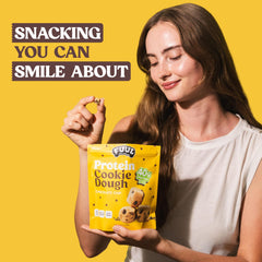 Persona sosteniendo un bocado FUUL Cookie Dough listos para consumir y energizar