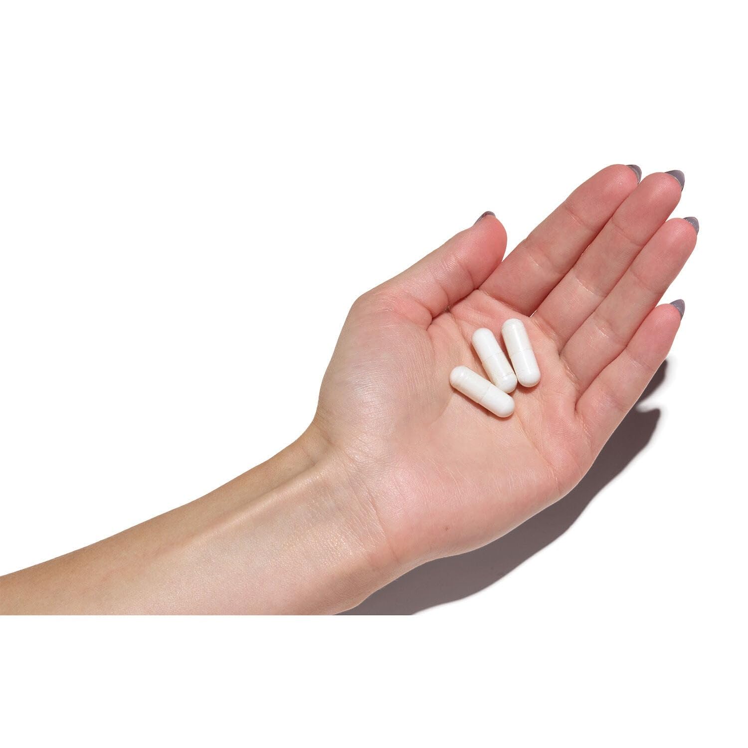 Cápsulas GNC Super Magnesium en mano para comparar tamaño y facilitar la toma diaria