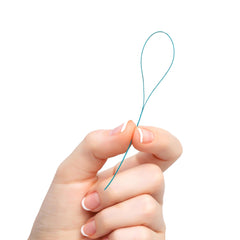 GUM Eez-Thru en uso guiando hilo dental por debajo de brackets para limpieza efectiva