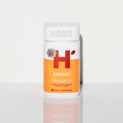 Health By Habit frasco junto a mano para comparar el tamaño de las cápsulas