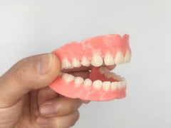 Healthyare primer plano de dientes postizos mostrando fila natural