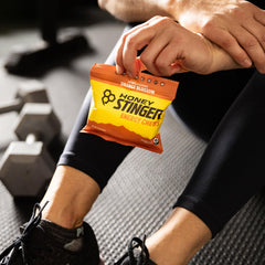 Honey Stinger masticable en mano para comparar tamaño práctico