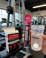 HyAqua tableta junto a una botella estándar para comparar tamaño y cantidad por dosis