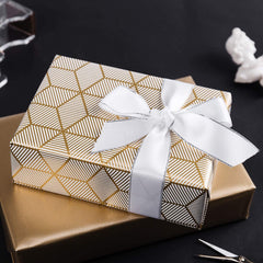 MAYPLUSS caja ya envuelta con papel blanco y dorado, presentación profesional