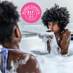 Duas botellas Mr. Bubble en ambiente de baño, enfatizando promoción y valor