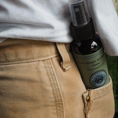 Nantucket Spider persona aplicando spray en sendero para protección