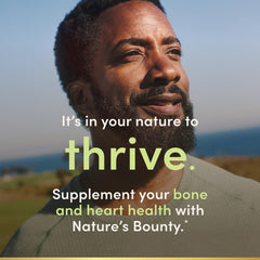 Nature's Bounty cápsula en mano para comparar escala y facilidad de ingestión