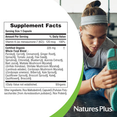 Persona sosteniendo cápsula de NaturesPlus Vitamin K2 mostrando facilidad de uso