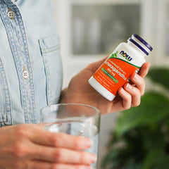 NOW Foods botella junto a taza y libreta sugiriendo uso cotidiano práctico