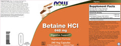 Comparación de tamaño de cápsula NOW Betaine HCl junto a una moneda para escala