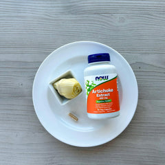 Now Foods cápsulas junto a moneda para comparar tamaño y porciones