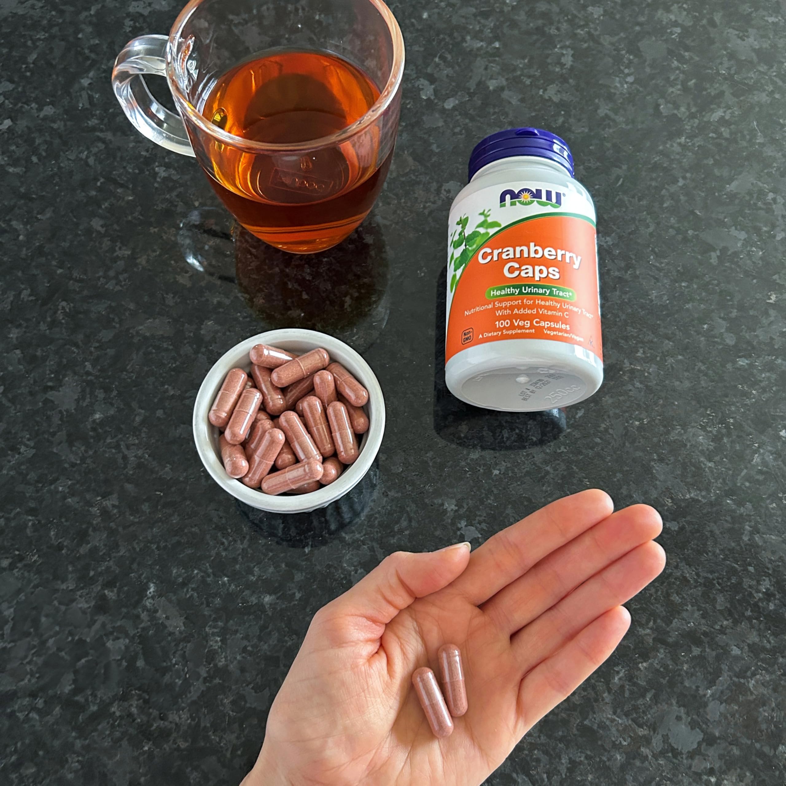 comparación de tamaño de cápsula NOW Foods Cranberry junto a moneda para escala visual