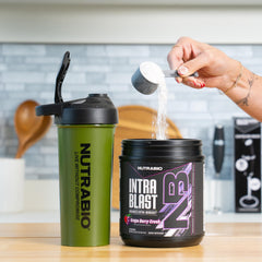 Vaso con NutraBio Intra Blast disuelto listo para beber durante el entrenamiento